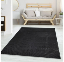 Covor negru cu model geometric de romb într-o cameră de zi luminoasă, mobilată modern, cu o canapea din lemn și mobilier alb.