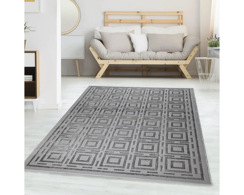 Covor gri cu model geometric pătrat într-o cameră de zi modernă și luminoasă, cu o canapea din lemn.