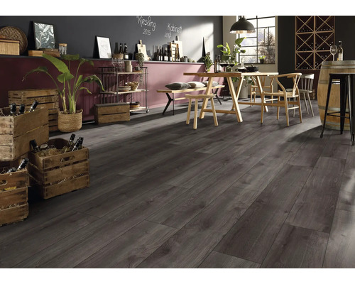 Pardoseală laminată aspect lemn închis într-o încăpere modernă cu masă din lemn și lăzi de vin.