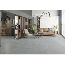 Zonă spațioasă de zi și bucătărie cu plăci de gresie gri de format mare cu aspect de piatră, canapea modernă și design industrial.