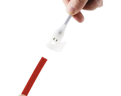 Mână care conectează un conector alb pentru bandă LED la o bandă LED roșie.