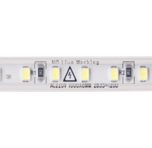 Vedere de aproape a unei benzi LED cu diode luminiscente, rezistențe, simbol de avertizare pentru tensiune electrică și instrucțiuni de siguranță.