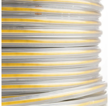 Vedere de aproape a unei benzi LED COB rulată într-o manșon de protecție transparent.
