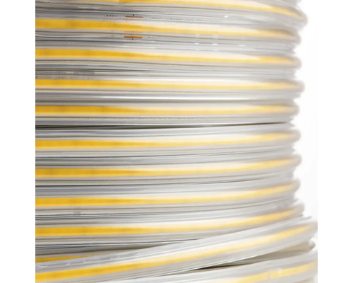 Vedere de aproape a unei benzi LED COB rulată într-o manșon de protecție transparent.