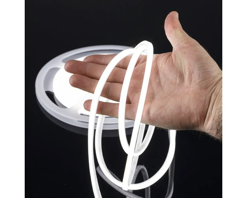 Bandă neon cu LED flexibilă cu lumină albă, ținută în mână.