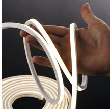 Bandă LED neon flexibilă, ținută în mână și iluminată.