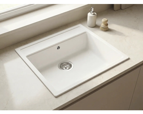 Chiuvetă de bucătărie încorporabilă dreptunghiulară albă, montată într-un blat deschis la culoare, cu sită de scurgere.