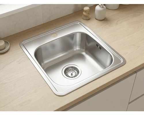 Chiuvetă de bucătărie încorporabilă din oțel inoxidabil într-un blat de lemn deschis cu o cuvă pătrată și preaplin.