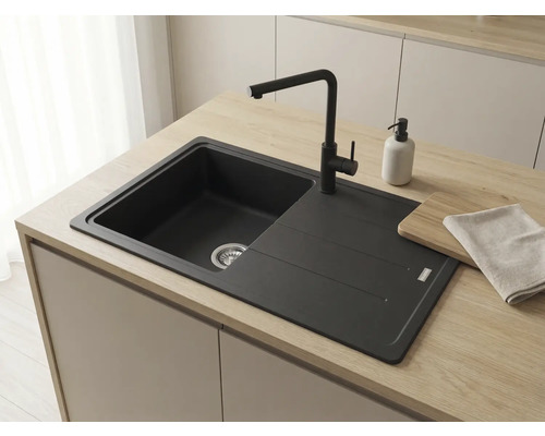 Chiuvetă de bucătărie încorporabilă de culoare neagră cu baterie asortată pe un blat de lemn deschis într-o bucătărie modernă.