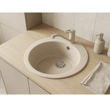 Chiuvetă de bucătărie rotundă încastrată, bej, din material compozit, cu baterie monocomandă asortată pe un blat cu aspect de lemn deschis.