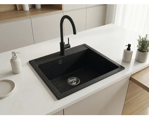 Chiuvetă de bucătărie modernă încastrată din compozit negru cu baterie neagră cu pipă înaltă pe un blat de bucătărie deschis la culoare.