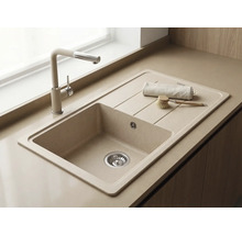 Chiuvetă încorporată din compozit de cuarț cu picurător și baterie de bucătărie asortată pe bej, design luminos și modern.