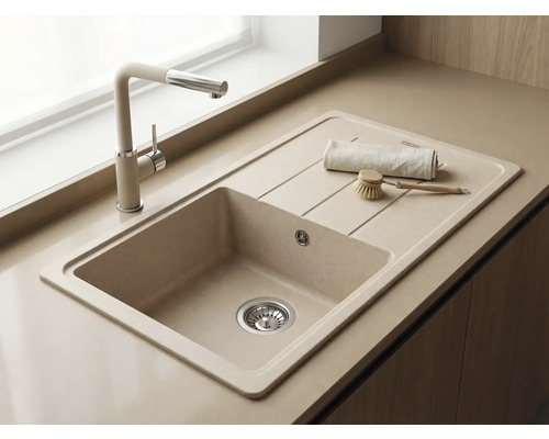 Chiuvetă încorporată din compozit de cuarț cu picurător și baterie de bucătărie asortată pe bej, design luminos și modern.