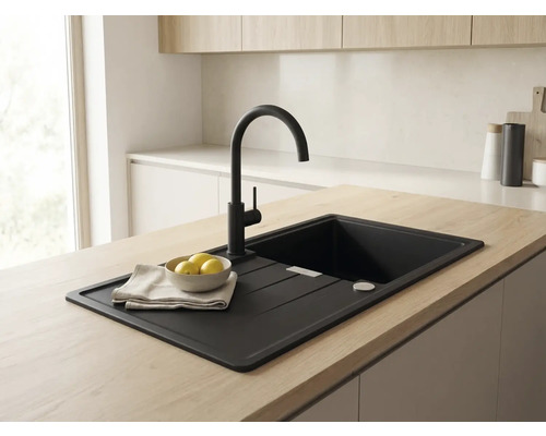 Chiuvetă de bucătărie încorporată, neagră, cu picurător și baterie neagră înaltă, pe o insulă de bucătărie cu blat din lemn deschis.