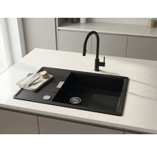 Chiuvetă de bucătărie modernă neagră cu picurător și baterie neagră pe un blat de lucru deschis la culoare.