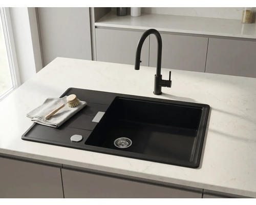 Chiuvetă de bucătărie modernă neagră cu picurător și baterie neagră pe un blat de lucru deschis la culoare.