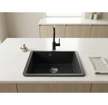 Insulă de bucătărie modernă cu chiuvetă dreptunghiulară închisă la culoare, baterie de bucătărie neagră și blat deschis la culoare.