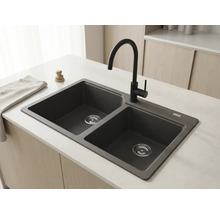 Chiuvetă dublă din compozit granit antracit cu baterie neagră înaltă pe o insulă de bucătărie deschisă într-o bucătărie luminoasă și organizată.