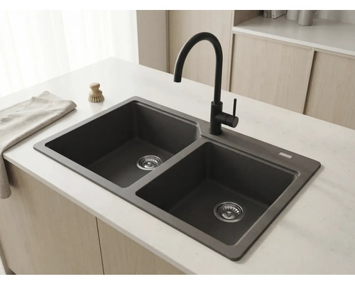 Chiuvetă dublă din compozit granit antracit cu baterie neagră înaltă pe o insulă de bucătărie deschisă într-o bucătărie luminoasă și organizată.