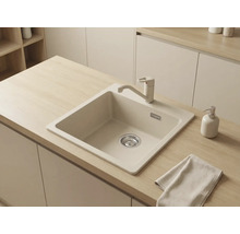 Chiuvetă încorporabilă bej cu baterie de bucătărie monocomandă asortată, montată într-un blat din lemn deschis într-o bucătărie modernă.