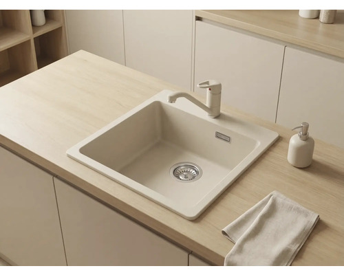 Chiuvetă încorporabilă bej cu baterie de bucătărie monocomandă asortată, montată într-un blat din lemn deschis într-o bucătărie modernă.