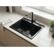 Chiuvetă de bucătărie neagră cu o singură cuvă și baterie neagră, încastrată într-un blat de lucru deschis la culoare într-o bucătărie modernă.