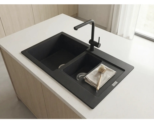 Chiuvetă dublă Franke din compozit de granit negru cu baterie neagră pe o insulă de bucătărie deschisă la culoare.