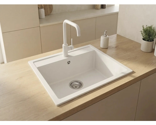 Chiuvetă încorporabilă albă modernă cu baterie albă pe un blat din lemn deschis într-o bucătărie minimalistă.