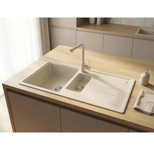 Chiuvetă încorporată cu o cuvă și jumătate, picurător și baterie asortată pe un blat de lemn deschis într-o bucătărie modernă.