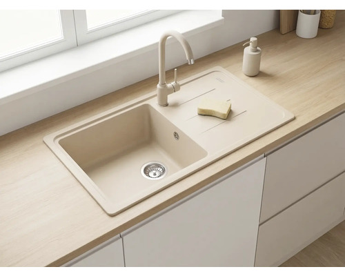 Bucătărie modernă, luminoasă, cu chiuvetă încorporabilă din compozit cu o cuvă și picurător, baterie asortată și blat cu aspect de lemn.