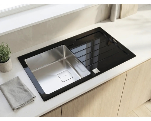 Chiuvetă de bucătărie Teka modernă cu cuvă din oțel inoxidabil și picurător din sticlă neagră, încorporată într-un blat deschis.