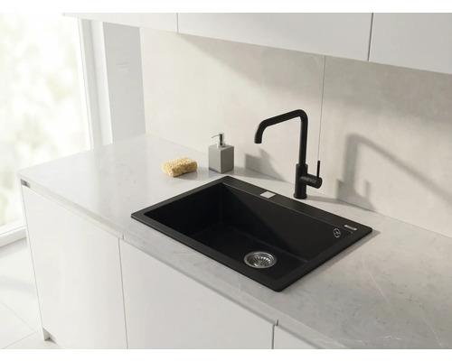 Bucătărie modernă cu chiuvetă încorporabilă neagră și baterie de bucătărie neagră pe un blat de lucru deschis la culoare cu aspect de marmură.