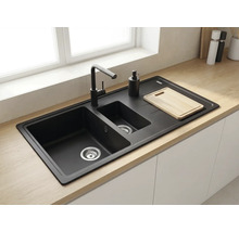 Chiuvetă încorporabilă neagră cu două cuve și picurător, inclusiv baterie neagră, montată într-un blat din lemn deschis la culoare.