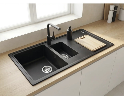 Chiuvetă încorporabilă neagră cu două cuve și picurător, inclusiv baterie neagră, montată într-un blat din lemn deschis la culoare.