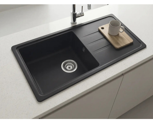 Chiuvetă încorporabilă dreptunghiulară neagră cu picurător, montată într-un blat de lucru deschis la culoare cu baterie cromată.