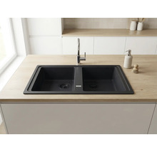 Chiuvetă dublă din compozit de granit într-un blat cu aspect de lemn, cu o baterie de bucătărie cromată, într-o bucătărie modernă.