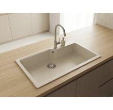 Chiuvetă de bucătărie încorporabilă din compozit bej cu baterie din oțel inoxidabil și dozator de săpun pe un blat de lemn.