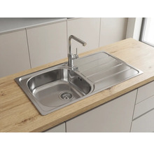 Chiuvetă încorporabilă din oțel inoxidabil cu o cuvă și picurător, montată în blat cu aspect de lemn și o baterie de bucătărie modernă.