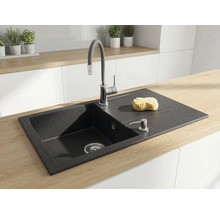 Chiuvetă de bucătărie încastrată din granit negru, cu picurător, baterie înaltă și dozator de săpun pe un blat din lemn deschis la culoare.