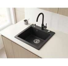 Chiuvetă modernă din granit negru cu baterie înaltă, dozator de săpun și control pentru scurgere pe un blat de bucătărie deschis la culoare.