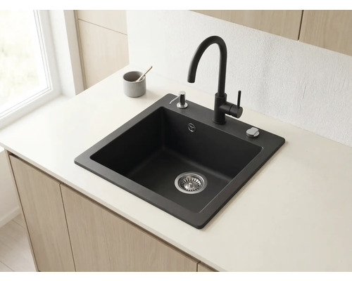 Chiuvetă modernă din granit negru cu baterie înaltă, dozator de săpun și control pentru scurgere pe un blat de bucătărie deschis la culoare.