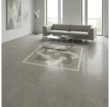 Cameră de zi modernă cu plăci de gresie gri mari cu aspect de piatră, decor geometric central, canapea și masă de sticlă.