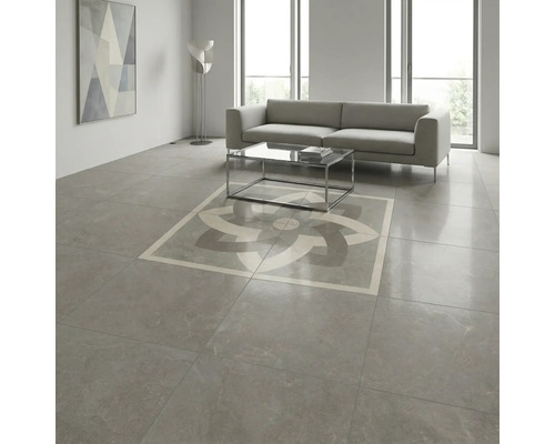 Cameră de zi modernă cu plăci de gresie gri mari cu aspect de piatră, decor geometric central, canapea și masă de sticlă.