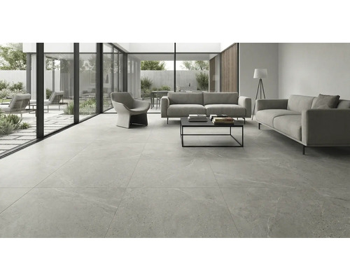 Cameră de zi modernă cu plăci de gresie gri de format mare cu aspect de piatră, două canapele, fotoliu și ferestre până la podea.