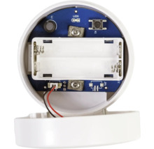 Vedere interioară a unui dispozitiv electronic cu compartiment pentru baterii gol pentru două baterii și o placă de circuit albastră.