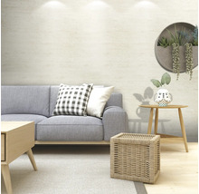 Tapet vlies cu aspect de piatră în bej deschis într-o cameră de zi modernă, cu canapea gri și mobilier din lemn.