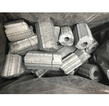 Brichete hexagonale din cărbune de lemn cu gaură în mijloc într-un sac.