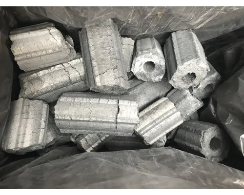 Brichete hexagonale din cărbune de lemn cu gaură în mijloc într-un sac.