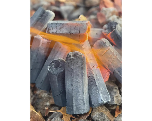 Brichete de grătar hexagonale cu gaură centrală, arzând cu flăcări.