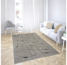 Covor gri modern cu model geometric negru într-o sufragerie luminoasă cu canapea albă și parchet tip brăduț.